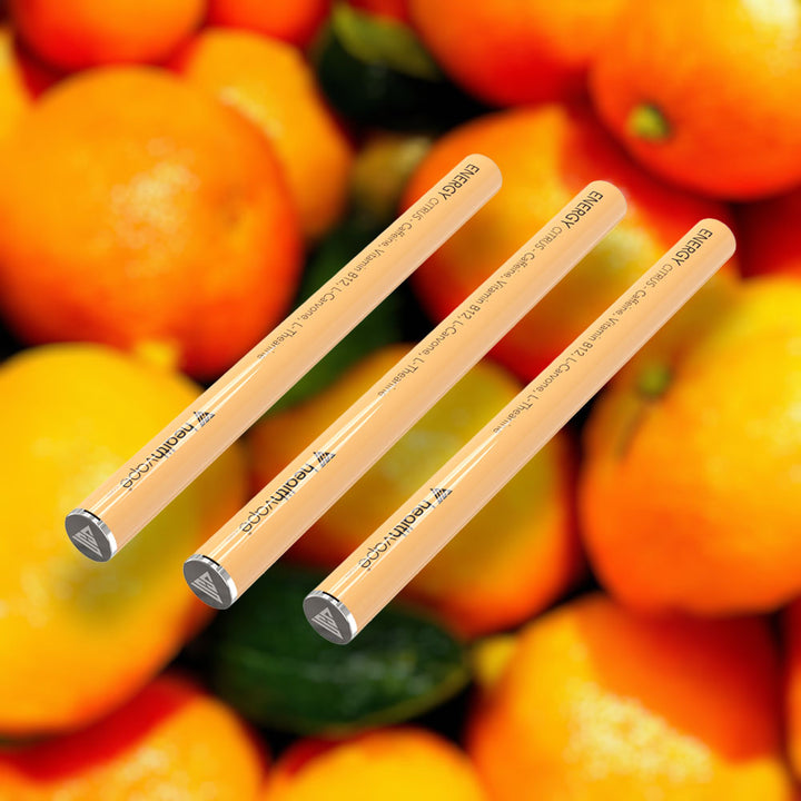 Three HealthVape ENERGY Citrus caffeine pens on fresh orange background