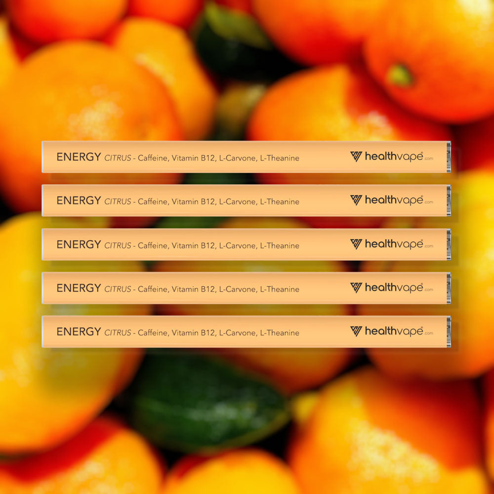 Five HealthVape ENERGY Citrus caffeine pens stacked on citrus fruit background