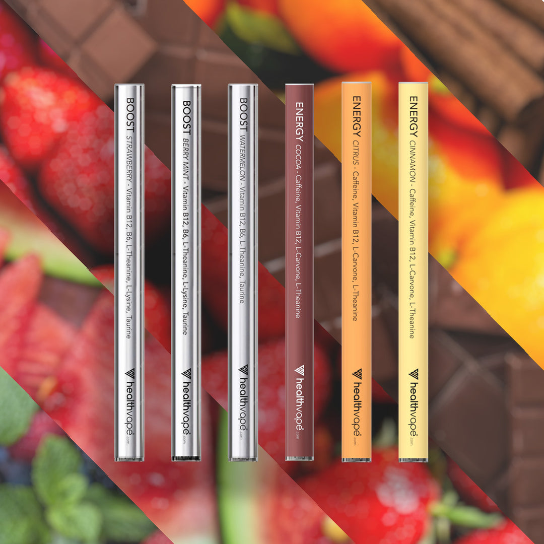Six HealthVape BOOST and ENERGY pens: B12 and caffeine variety on fruit and chocolate background