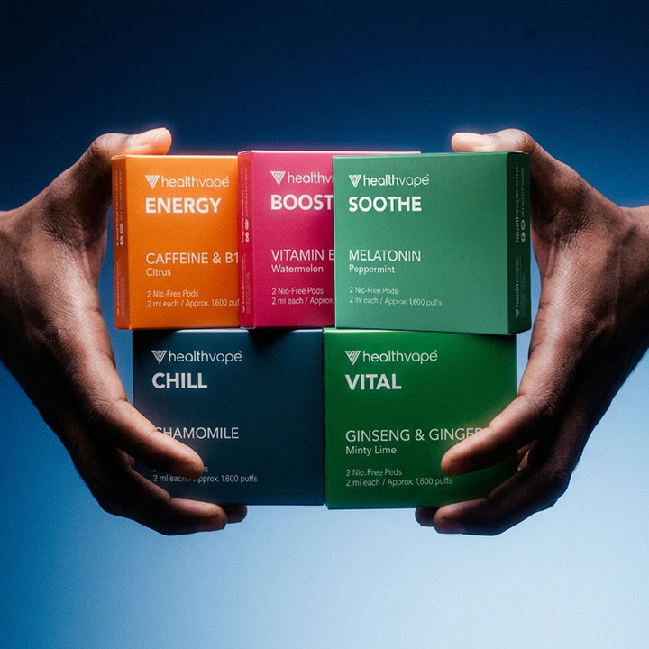 Hands holding five HealthVape pod boxes: Energy, Boost, Soothe, Chill, and Vital