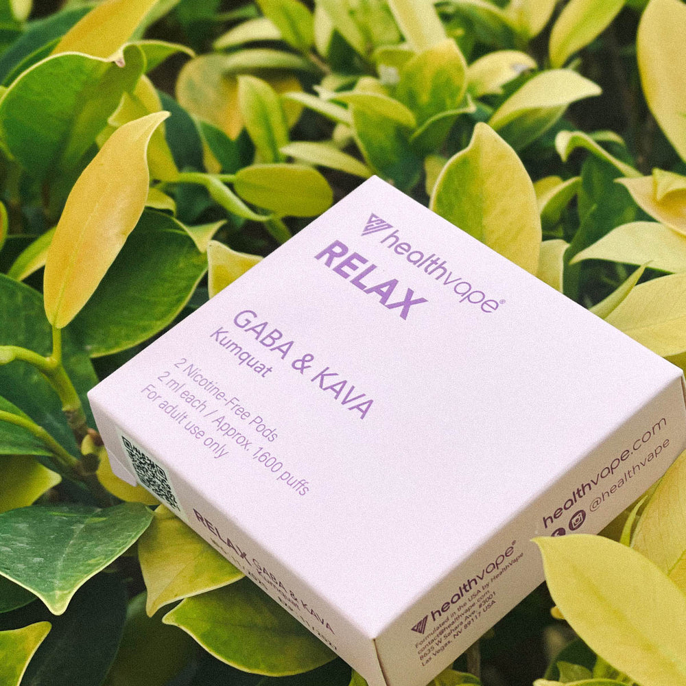HealthVape RELAX Kumquat GABA & Kava pod box on green foliage outdoors