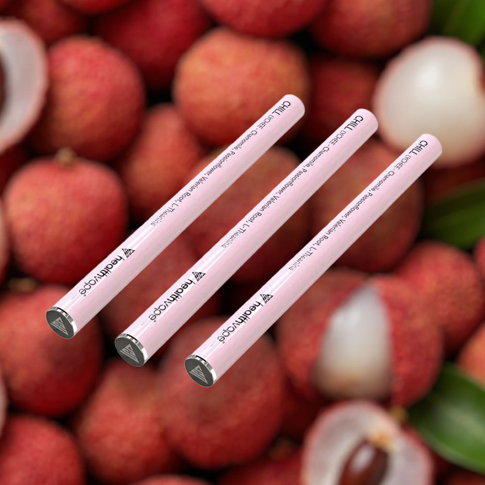 Three HealthVape CHILL Lychee chamomile pens on lychee fruit background
