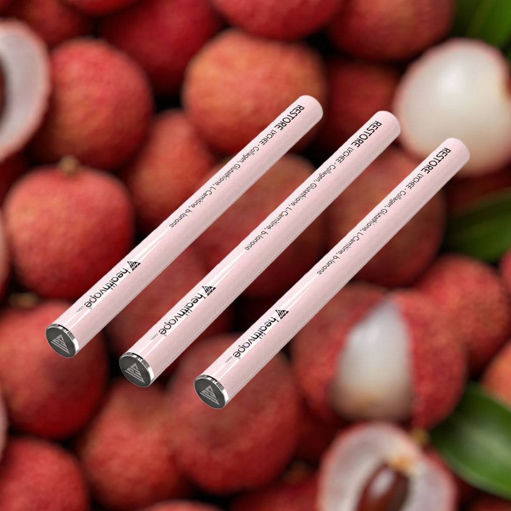 Three HealthVape RESTORE Lychee collagen pens on lychee fruit background
