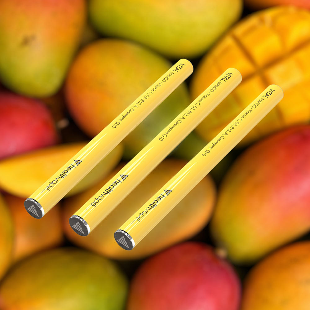 Three HealthVape VITAL Mango Vitamin C pens on mango fruit background