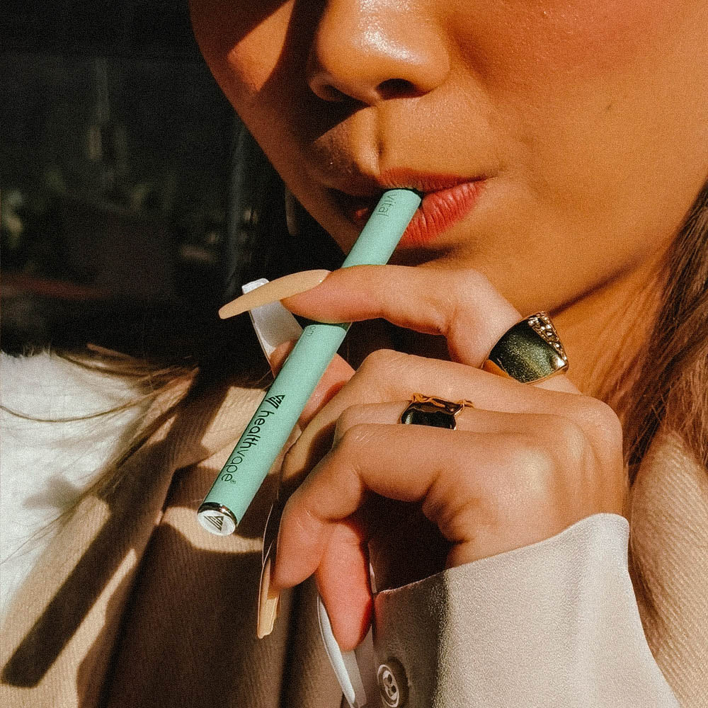 Close-up of woman holding green HealthVape Vital Vitamin C Kiwi vape pen